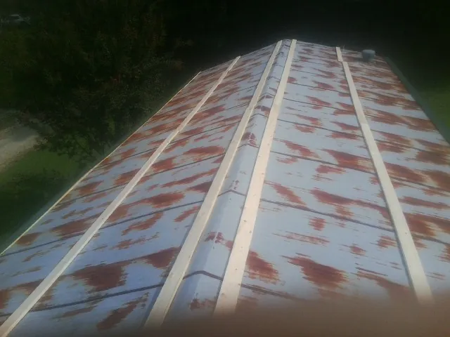 Rusted metal roof panels with new wood purlins before replacement — Storm Damage Roof Repair in Normangee by Roofing Brothers