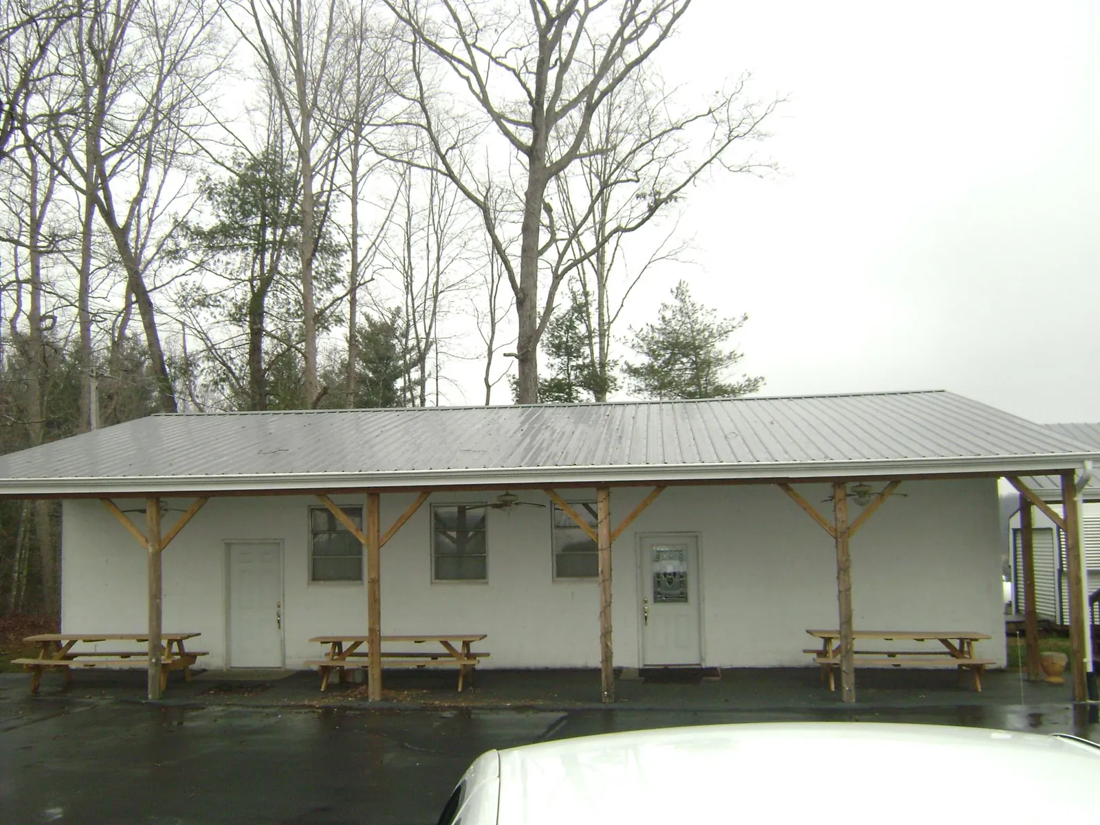 Gray metal roof over a block building with a timber post porch in Normangee